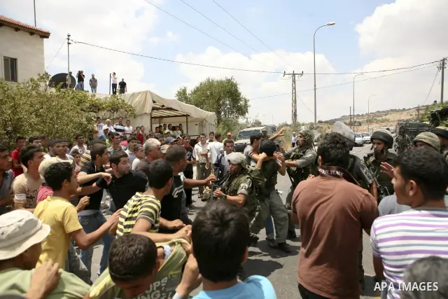 Palestinians scuffle with Israeli soldiers in the West Bank village of Lubban al-Gharbia on July 21, 2010 after Israeli forces demolished two houses and four shops that were built without the army's permit near a road le...