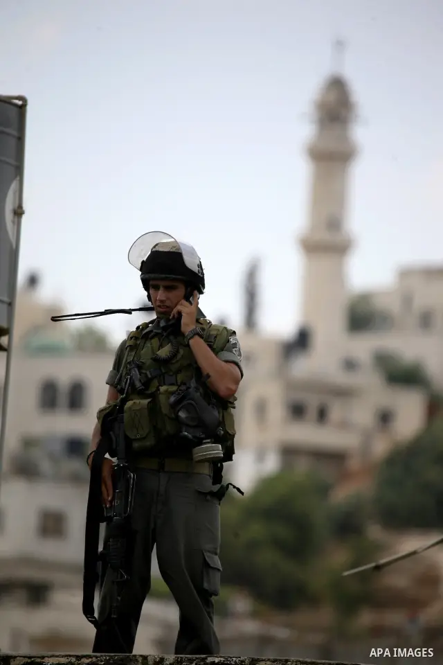 An Israeli soldier stands guard during clashes with Palestinians in the West Bank village of Lubban al-Gharbia on July 21, 2010 after Israeli forces demolished two houses and four shops that were built without the army's...