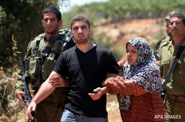 A Palestinian man argues with Israeli forces as he is taken away from his land which has been occupied by tents of armed Jewish ideological settlers (unseen) who are setting up a new outpost near the Israeli settlement o...