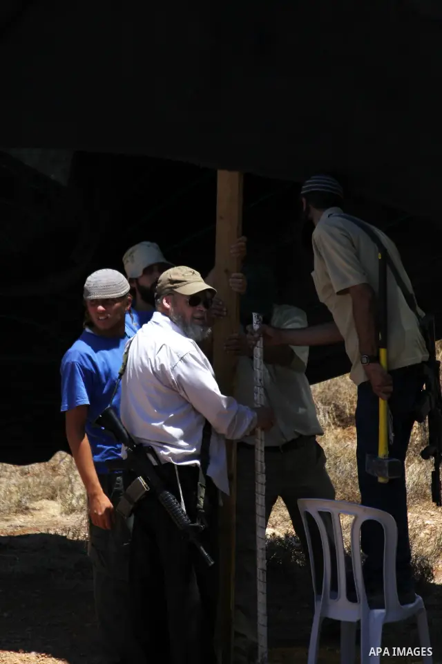 Armed Jewish ideological settlers set up tents on Palestinian land as they try to establish a new outpost near the Israeli settlement of Kharsina on 23 July 2010 east of Hebron, in the occupied West Bank. Photo by Mamoun...