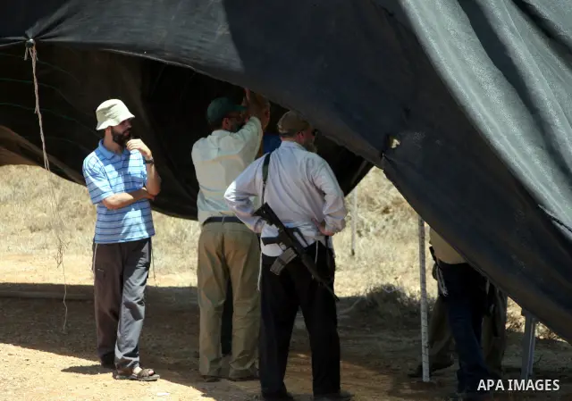 Armed Jewish ideological settlers set up tents on Palestinian land as they try to establish a new outpost near the Israeli settlement of Kharsina on 23 July 2010 east of Hebron, in the occupied West Bank. Photo by Mamoun...