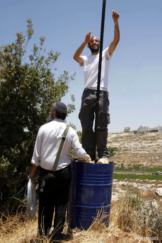 Armed Jewish ideological settlers set up tents on Palestinian land as they try to establish a new outpost near the Israeli settlement of Kharsina on 23 July 2010 east of Hebron, in the occupied West Bank. Photo by Mamoun...
