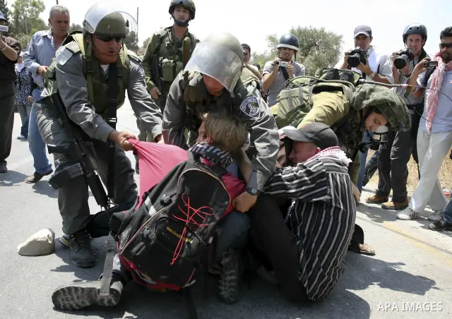 Israeli soldiers detain demonstrators during a protest against the expansion of the nearby Jewish settlement of Halamish in the West Bank village of Nabi Saleh, Friday, July 23, 2010. Photo by Eyad Jadallah