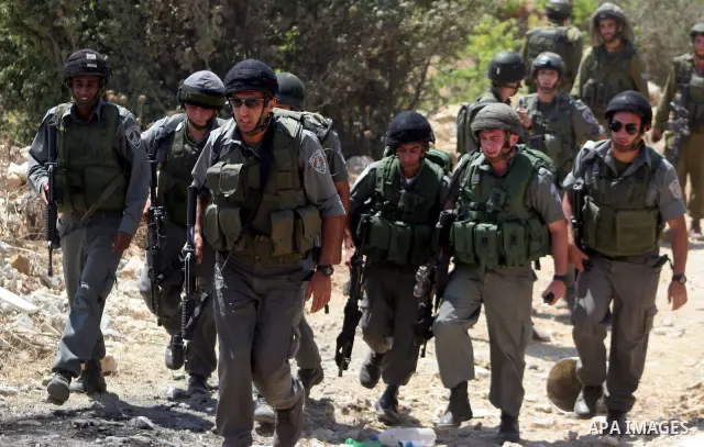 Israeli soldiers guards during a demonstration against Israel's controversial separation barrier in the village of Beit Omar near Jewish settlement of Karmi zur near the West Bank city of Hebron, on 24 July 2010. Photo b...