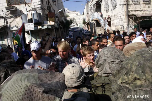 Israeli soldiers stand guards during the weekly protest against the closing of Al-Shuhada Street in the West Bank old city of Hebron on July 24,2010. Palestinians, Israelis and International peace activists protest weekl...