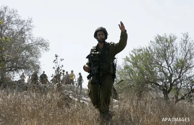 Jewish settlers sling rocks towards Palestinians during clashes close to the northern West Bank village of Burin on July 26, 2010, which began when Israeli troops removed two mobile homes set up near the Bracha settlemen...