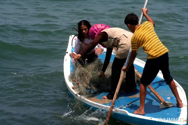 Madlin, her brother Kayed and sister Reem , take their small boat to fish off the coast of Gaza City on July 25, 2010. Madlin is the first girl in the Gaza Strip to fish professionally in order to support her poor family...