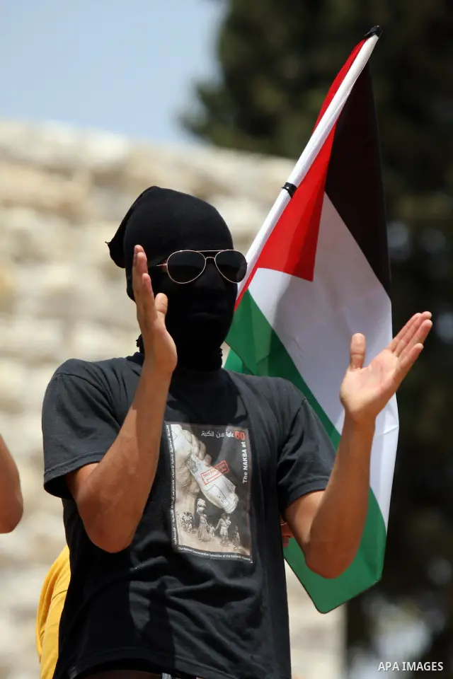 Palestinian, Israeli and international activists take part in a demonstration against the expansion of the nearby Jewish settlement of Halamish in the West Bank village of Nabi Saleh near Ramallah , Friday, July 30, 2010...