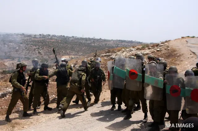 Israeli soldiers fire tear gas canisters at demonstrators during a protest against Israel's separation barrier in the West Bank village of Bilin near Ramallah, Friday, July 30, 2010. Photo by Wagdi Eshtayah