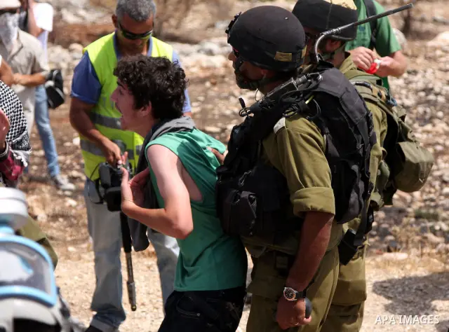 Protesters scuffle with Israeli soldiers during a protest against Israel's separation barrier in the West Bank village of Bilin near Ramallah, Friday, July 30, 2010. Photo by Wagdi Eshtayah