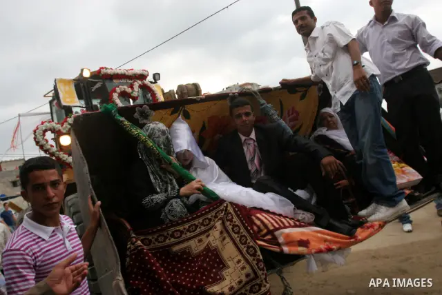 A Palestinian groom Hussein Nwaga'a rides with his bride a bulldozer during their wedding ceremony in Gaza city on July 30, 2010. Hussein used his stopped bulldozer since the Israeli blockade for his wedding ceremony to...