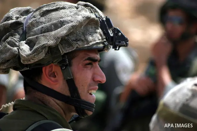 Israeli soldiers stand guards as Palestinian and foreign protesters take part in a demonstration against Israel's controversial separation barrier in the village of Beit Omar near Jewish settlement of Karmi zur near the...