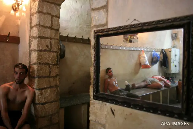 Palestinians take a steam bath at the ancient archaeological bath "Hamam al-Samra", in Gaza City, August 1, 2010. The bathhouse has survived centuries of conflict and these days the owner uses Asian massage therapy to ea...