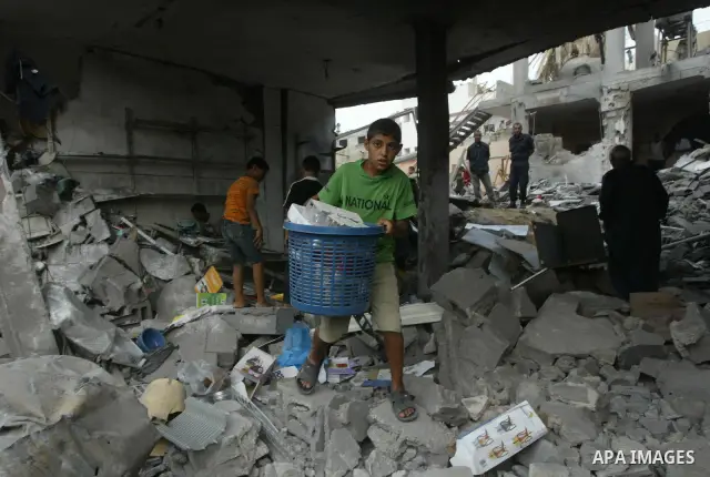 Palestinians look at the damage following a blast at the house of a Hamas commander in the Deir el-Balah refugee camp, central Gaza Strip, Monday, August 2, 2010. Early Monday, a huge blast leveled the house of a Hamas c...