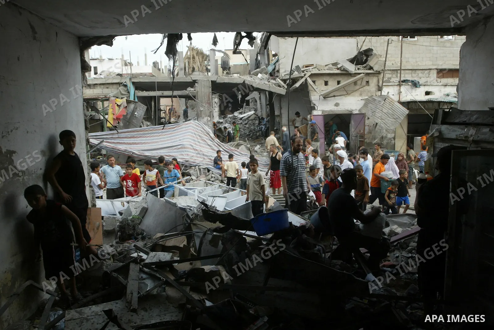 Palestinians look at the damage following a blast at the house of a Hamas commander in the Deir el-Balah refugee camp, central Gaza Strip, Monday, August 2, 2010. Early Monday, a huge blast leveled the house of a Hamas c...