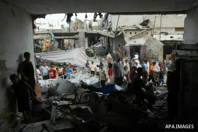 Palestinians look at the damage following a blast at the house of a Hamas commander in the Deir el-Balah refugee camp, central Gaza Strip, Monday, August 2, 2010. Early Monday, a huge blast leveled the house of a Hamas c...