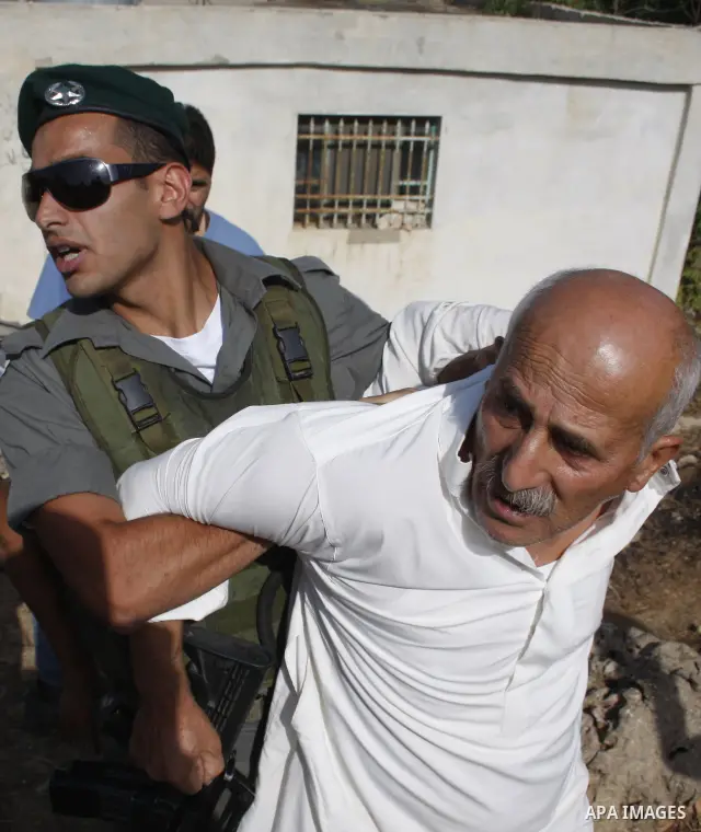 Israeli border policemen arrest Palestinian man during scuffles in the West Bank city of Hebron on August 2, 2010 after Israeli authorities destroyed the irrigation system in the Jaber family's land. Photo by Mamoun Wazw...