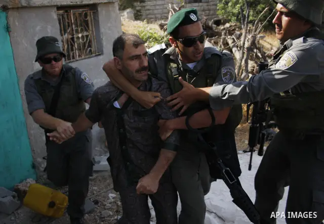 Israeli border policemen arrest Palestinian man during scuffles in the West Bank city of Hebron on August 2, 2010 after Israeli authorities destroyed the irrigation system in the Jaber family's land. Photo by Mamoun Wazw...