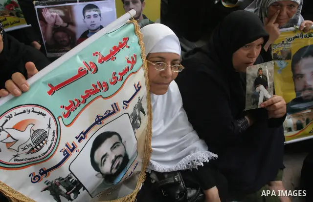 Palestinian women hold pictures of jailed relatives during a protest calling for the release of Palestinian prisoners from Israeli jails at the Red Cross office in Gaza City on August 2,2010. Photo by Mohammed Asad