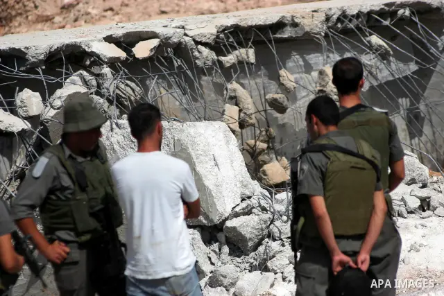 Israeli soldiers guard an army bulldozer destroying Palestinians wells in the West Bank city of Hebron on August 4,2010. Photo by Mamoun Wazwaz