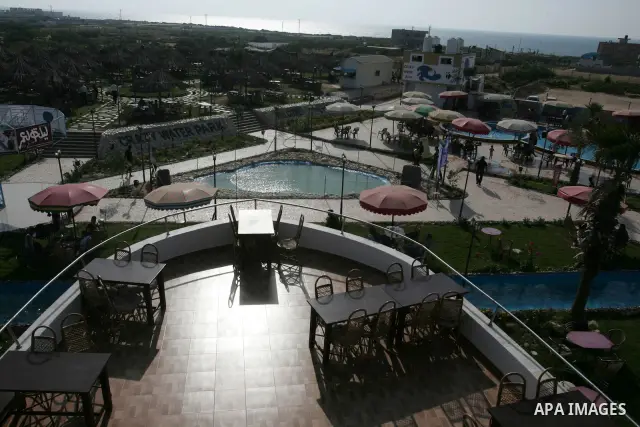 Palestinians sit at Crazy Water Park in Gaza City August 8, 2010. New leisure projects and restaurants have been springing up in the Gaza Strip, some partially funded by Hamas Islamists ruling a territory long seen as a...