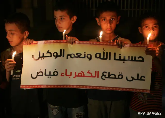 Palestinian children light candles during a protest against a power cut in Gaza City on August 8, 2010. The Gaza Strip's sole power plant shut down on Saturday for lack of diesel fuel, a Palestinian power authority offic...