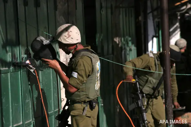 Israeli border policemen close a metal welding workshop in the Israeli occupied West Bank city of Hebron, Tuesday on August 10, 2010. Photo by Mamoun Wazwaz