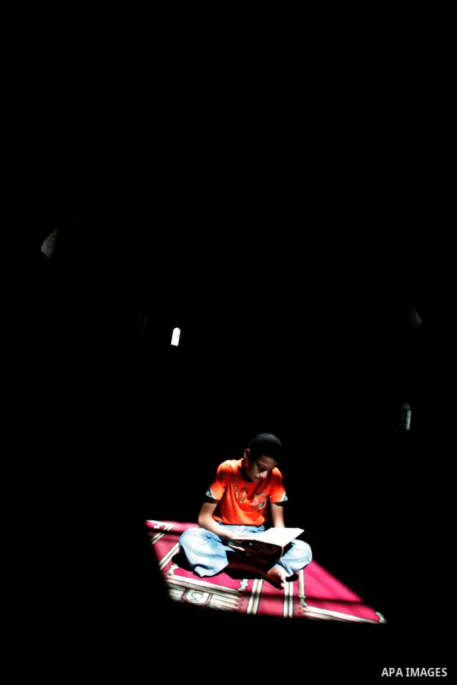 A Palestinian boy read Holy Quraan on the first day of the holy month of Ramadan in Rafah in the southern Gaza Strip on August 11,2010. Muslims all over the world fast from dawn to dusk during the holy month of Ramadan i...