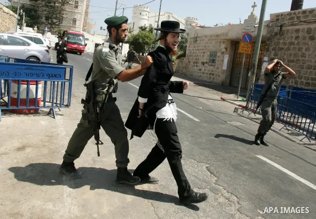 An ultra-Orthodox Jew is grabbed by an Israeli Border policeman during a protest in the coastal town of Jaffa, just south of Tel Aviv, on 12 August 2010 over the town's decision to remove ancient graves found during the...