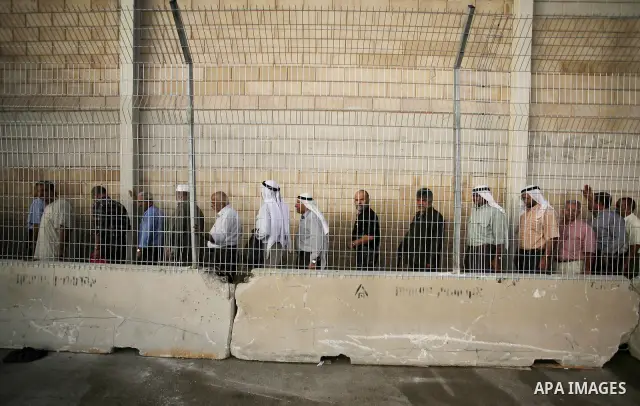Palestinian Muslim men wait to cross the Isreali controlled Qalandia checkpoint on the outskirts of the West Bank city of Ramallah on August 13, 2010 to reach the Al-Aqsa mosque compound in Jerusalem's old city and atten...