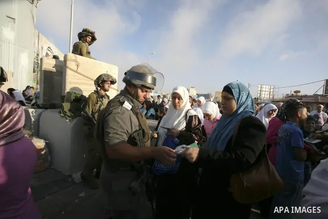 Palestinian Muslim women wait to cross the Isreali controlled Qalandia checkpoint on the outskirts of the West Bank city of Ramallah on August 13, 2010 to reach the Al-Aqsa mosque compound in Jerusalem's old city and att...