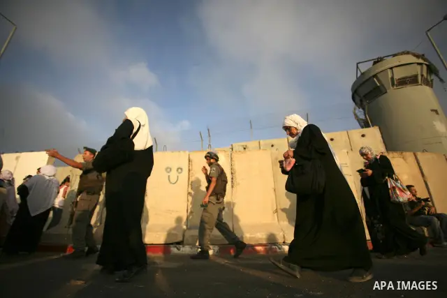 Palestinian Muslim women wait to cross the Isreali controlled Qalandia checkpoint on the outskirts of the West Bank city of Ramallah on August 13, 2010 to reach the Al-Aqsa mosque compound in Jerusalem's old city and att...