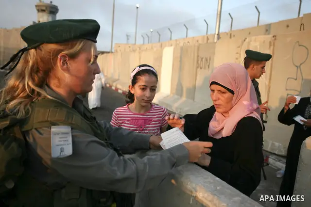 Palestinian Muslim women wait to cross the Isreali controlled Qalandia checkpoint on the outskirts of the West Bank city of Ramallah on August 13, 2010 to reach the Al-Aqsa mosque compound in Jerusalem's old city and att...