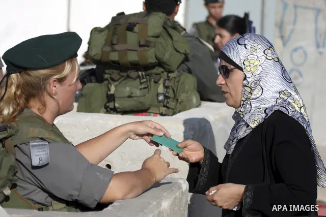Palestinian Muslim women wait to cross the Isreali controlled Qalandia checkpoint on the outskirts of the West Bank city of Ramallah on August 13, 2010 to reach the Al-Aqsa mosque compound in Jerusalem's old city and att...