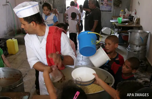 Palestinian children receive donated food from an Islamic charity on the fourth day of the Muslim holy month of Ramadan, in the West Bank city of Nablus, Saturday, August 14, 2010. Devout Muslims refrain from eating, dri...