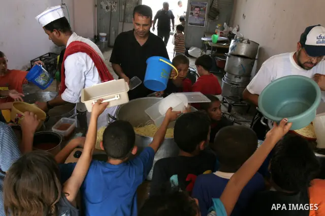 Palestinian children receive donated food from an Islamic charity on the fourth day of the Muslim holy month of Ramadan, in the West Bank city of Nablus, Saturday, August 14, 2010. Devout Muslims refrain from eating, dri...