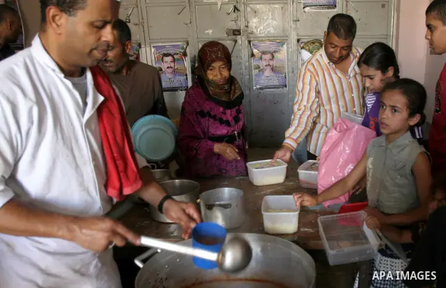 Palestinian children receive donated food from an Islamic charity on the fourth day of the Muslim holy month of Ramadan, in the West Bank city of Nablus, Saturday, August 14, 2010. Devout Muslims refrain from eating, dri...