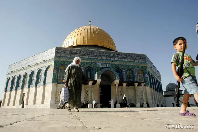 Palestinian Muslims walk in front of the Dome of the Rock on the compound known to Muslims as al-Haram al-Sharif and to Jews as Temple Mount during the seventh day of the holy month of Ramadan in Jerusalem's Old City Aug...
