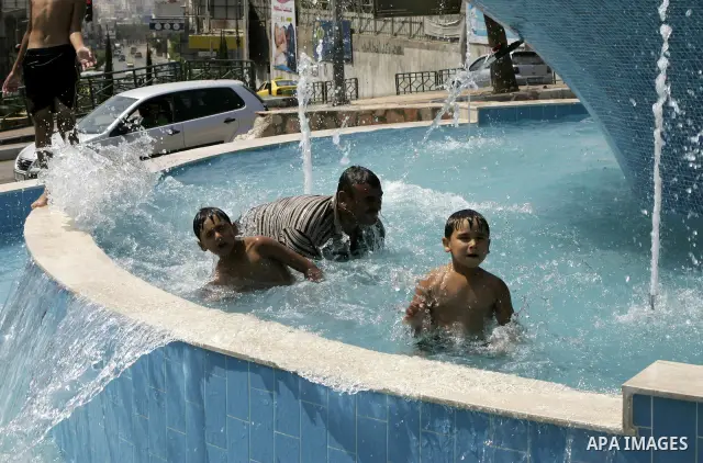 Palestinian children enjoy themselves in a water pool in the West Bank city of Nablus on August 18,2010 . Photo by Wagdi Eshtayah