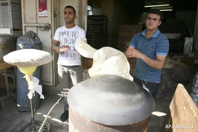Palestinian vendor makes bread at his shop on the eighth day of the holy month of Ramadan in the West Bank city of Ramallah on August 18. 2010. Photo by Eyad Jadallah