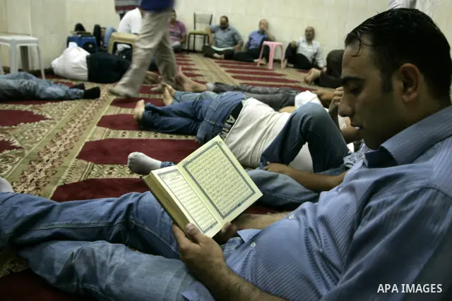 Palestinians read holy Koran and other sleep at mosque on the ninth day of the Muslim holy month of Ramadan, in the West Bank city of Nablus, Thursday, Aug. 19, 2010. Devout Muslims refrain from eating, drinking and smok...