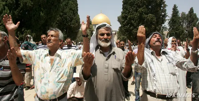 Palestinian worshippers pray outside the Dome of the Rock at the flashpoint Al-Aqsa mosque compound in Jerusalem during the second Friday noon prayer of the holy fasting month of Ramadan on August 20, 2010 for which Isra...