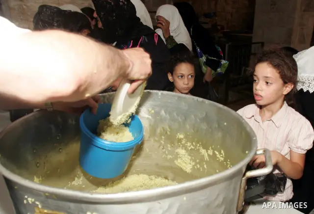 Palestinians receive donated food from an Islamic charity on the eleventh day of the Muslim holy month of Ramadan, in Jerusalem's old city, Saturday, August 21, 2010. Devout Muslims refrain from eating, drinking and smok...