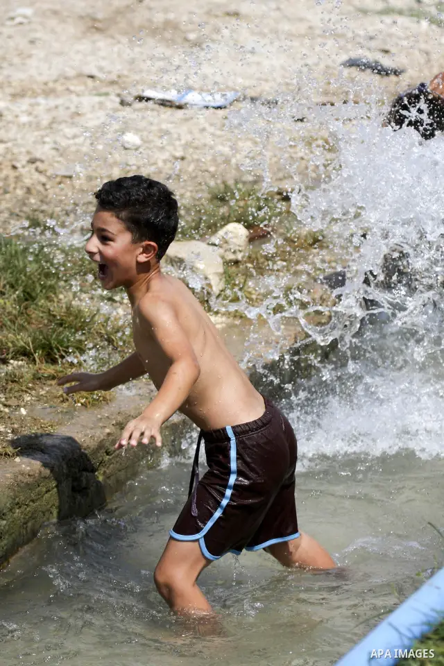 Palestinians cool off in the water of a natural spring known as Ein al-Sultan, near the West Bank city of Jericho on August 22, 2010. Photo by Eyad Jadallah