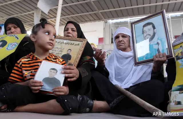 Palestinian women and children hold pictures of jailed relatives during a protest calling for the release of Palestinian prisoners from Israeli jails at the Red Cross office in Gaza City on August 23,2010. Photo by Moham...