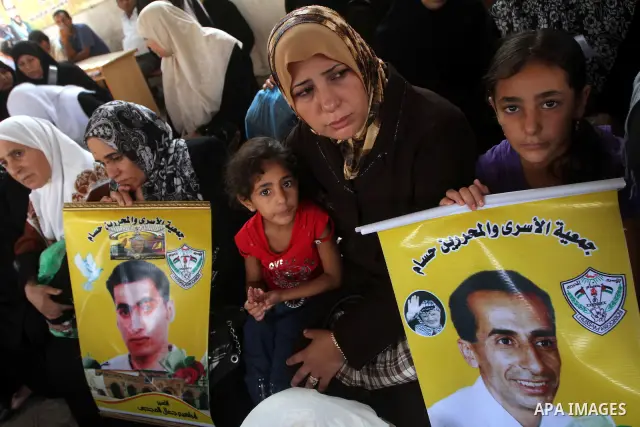 Palestinian women and children hold pictures of jailed relatives during a protest calling for the release of Palestinian prisoners from Israeli jails at the Red Cross office in Gaza City on August 23,2010. Photo by Ashra...
