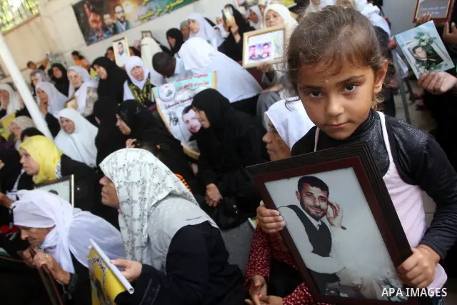 Palestinian women and children hold pictures of jailed relatives during a protest calling for the release of Palestinian prisoners from Israeli jails at the Red Cross office in Gaza City on August 23,2010. Photo by Ashra...