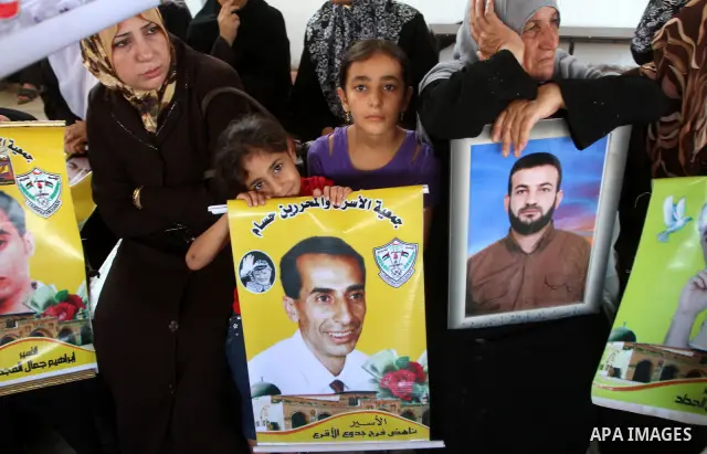 Palestinian women and children hold pictures of jailed relatives during a protest calling for the release of Palestinian prisoners from Israeli jails at the Red Cross office in Gaza City on August 23,2010. Photo by Ashra...