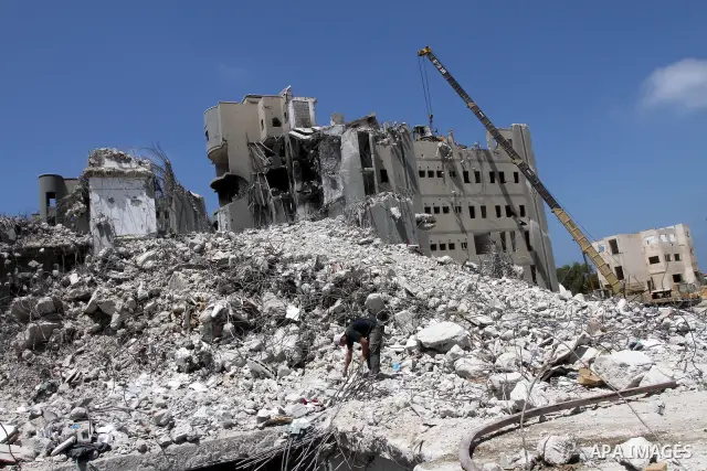 Palestinian men extract the iron from the ministries buildings which were destroyed during the 22-day Israeli war on Gaza, in Gaza city on August 24, 2010. Photo by Ashraf Amra.