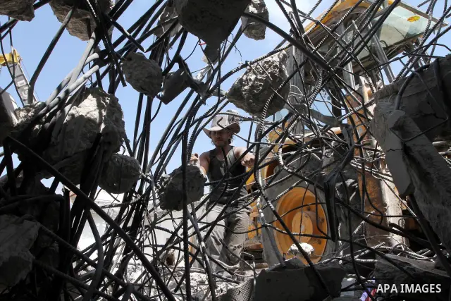 Palestinian men extract the iron from the ministries buildings which were destroyed during the 22-day Israeli war on Gaza, in Gaza city on August 24, 2010. Photo by Ashraf Amra.